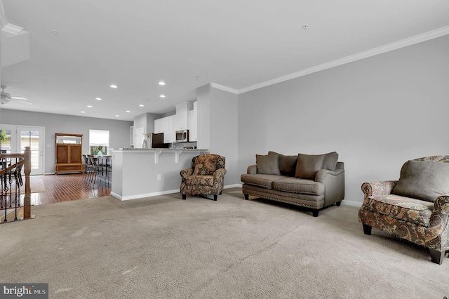 living area with light colored carpet, recessed lighting, baseboards, crown molding, and a ceiling fan