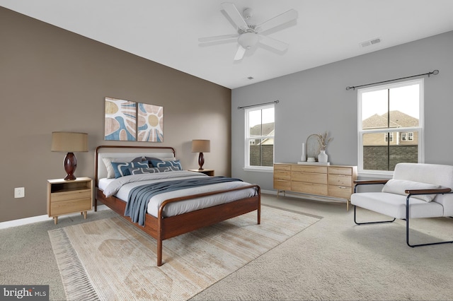 bedroom with light carpet, baseboards, and a ceiling fan