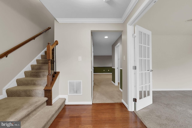 stairs with ornamental molding, baseboards, and wood finished floors