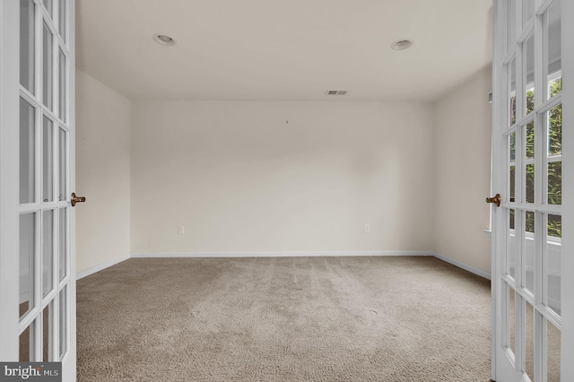 carpeted empty room featuring french doors, baseboards, and recessed lighting