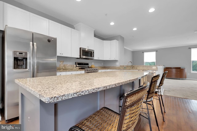 kitchen featuring stainless steel appliances, recessed lighting, white cabinetry, light wood-type flooring, and a peninsula