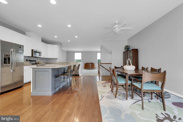 dining space with recessed lighting, light wood-type flooring, a ceiling fan, and baseboards