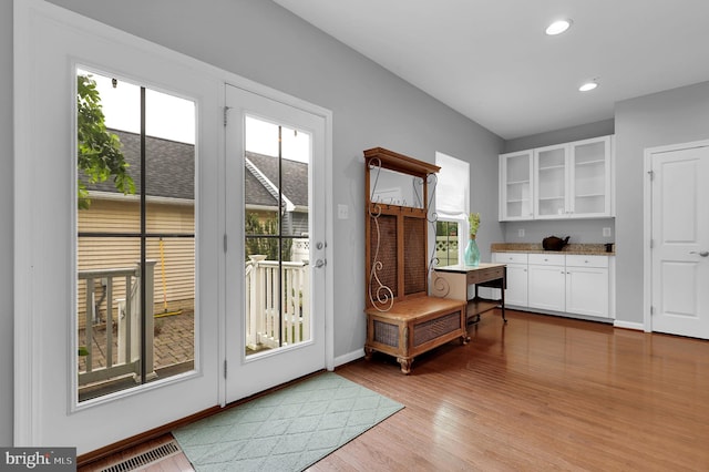 doorway to outside featuring light wood-style flooring, baseboards, and recessed lighting