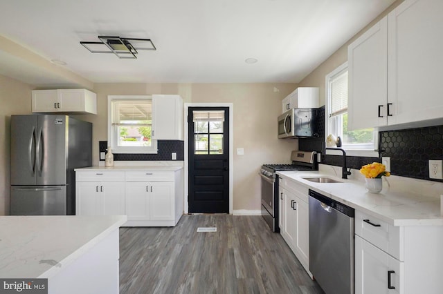1208 Krueger Ave, Rosedale, MD 21237 - kitchen featuring stainless steel appliances, a sink, wood finished floors, decorative backsplash, and healthy amount of natural light