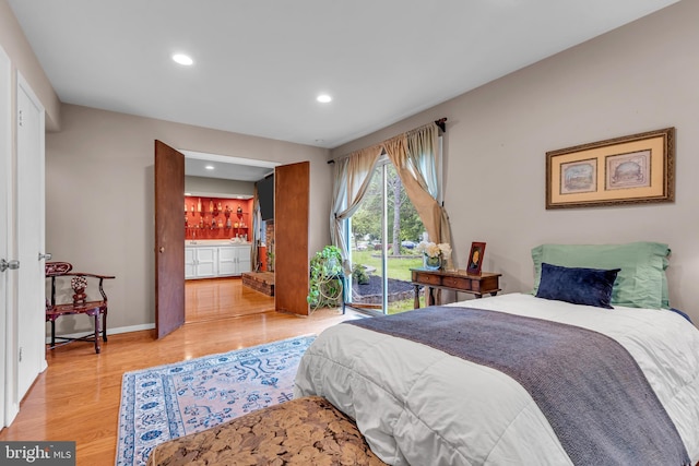 bedroom featuring light wood-type flooring, recessed lighting, bar area, baseboards, and access to exterior