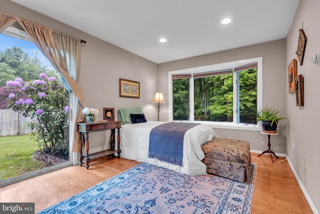 bedroom featuring recessed lighting, baseboards, wood finished floors, and access to outside