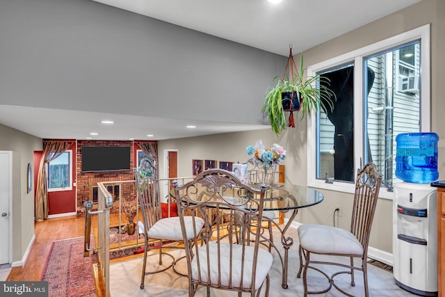 dining area featuring baseboards, wood finished floors, recessed lighting, and a brick fireplace