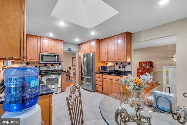 kitchen with stainless steel appliances, decorative backsplash, dark countertops, recessed lighting, and light tile patterned floors