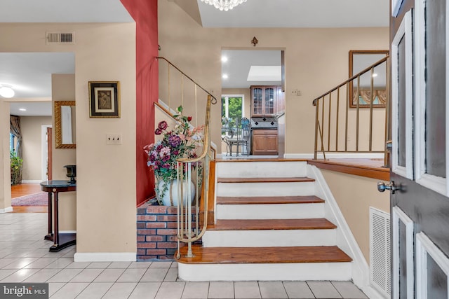 stairway with tile patterned floors and baseboards