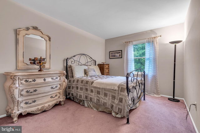 bedroom featuring light colored carpet and baseboards