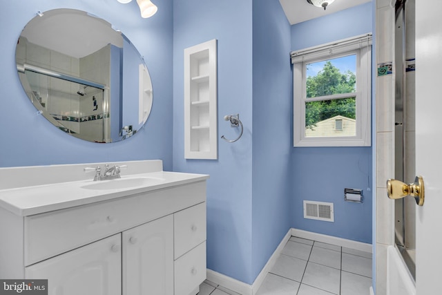 bathroom with an enclosed shower, tile patterned flooring, baseboards, and vanity