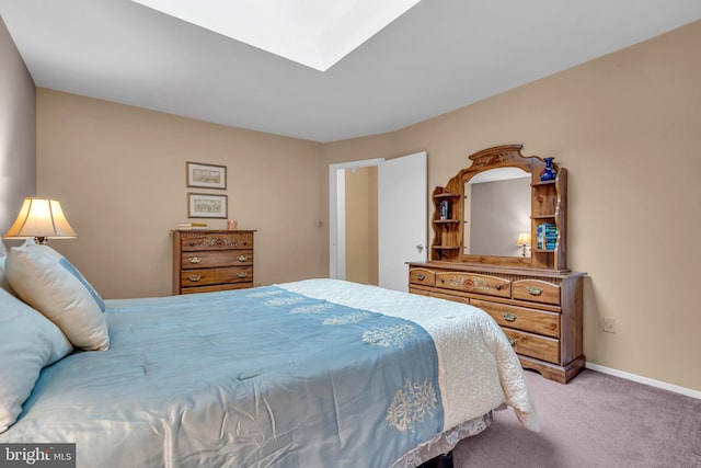 carpeted bedroom with baseboards and a skylight