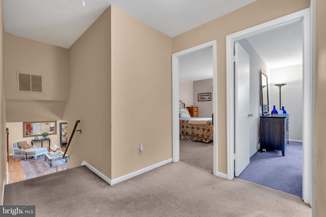 corridor with carpet flooring, an upstairs landing, and baseboards