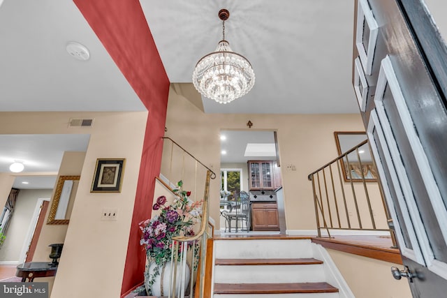 entryway with stairs, a chandelier, and baseboards