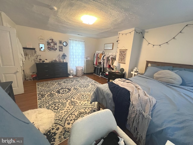 619 S Cameron St, Winchester, VA 22601 - bedroom with wood finished floors, a textured ceiling, and radiator heating unit