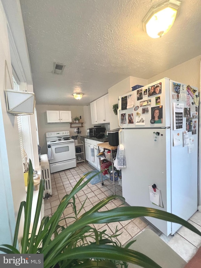 619 S Cameron St, Winchester, VA 22601 - kitchen with white appliances, white cabinets, a textured ceiling, and light tile patterned flooring