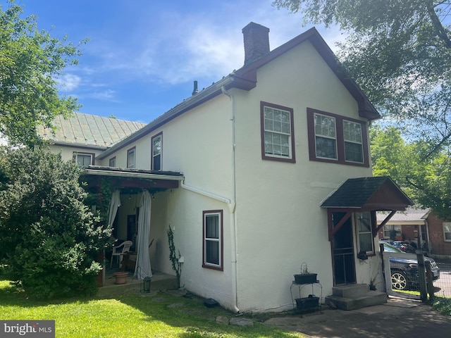619 S Cameron St, Winchester, VA 22601 - back of house featuring a chimney, stucco siding, and a lawn