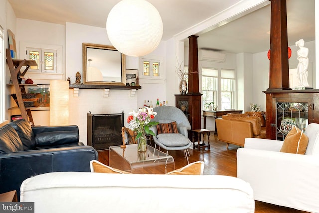 730 Fillmore St, Harpers Ferry, WV 25425 - living area with a brick fireplace, ornate columns, wood finished floors, and a wall mounted air conditioner