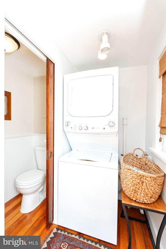 730 Fillmore St, Harpers Ferry, WV 25425 - washroom with stacked washing machine and dryer, wood finished floors, and a wainscoted wall
