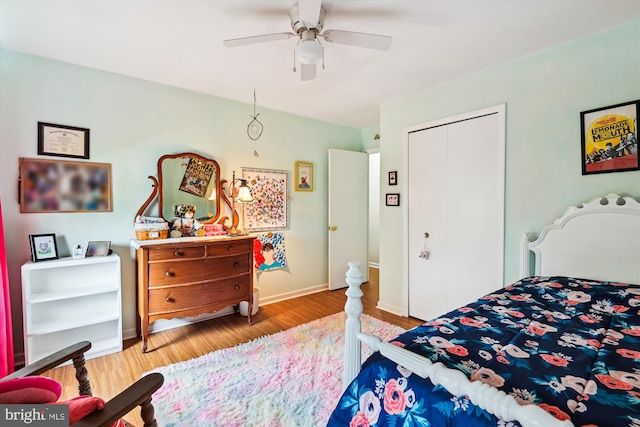bedroom featuring a closet, wood finished floors, a ceiling fan, and baseboards