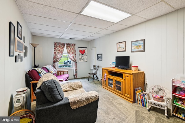 living room featuring carpet flooring and a drop ceiling