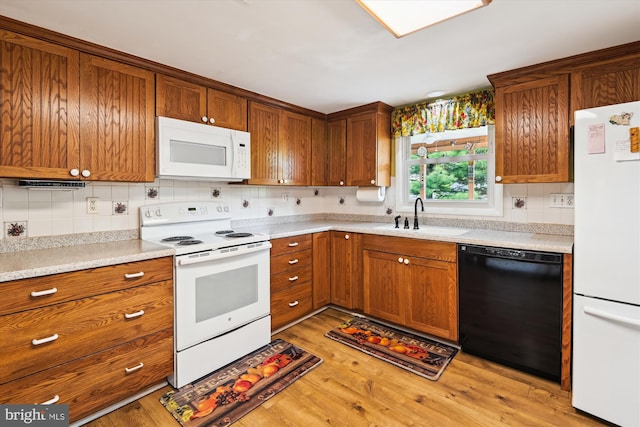 kitchen with white appliances, a sink, and brown cabinets