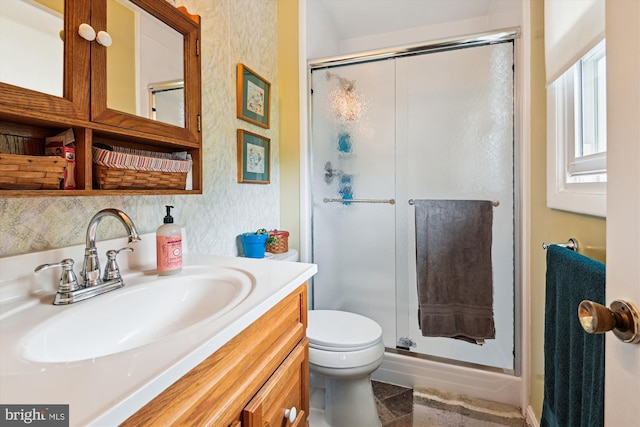 bathroom featuring a stall shower, toilet, and vanity