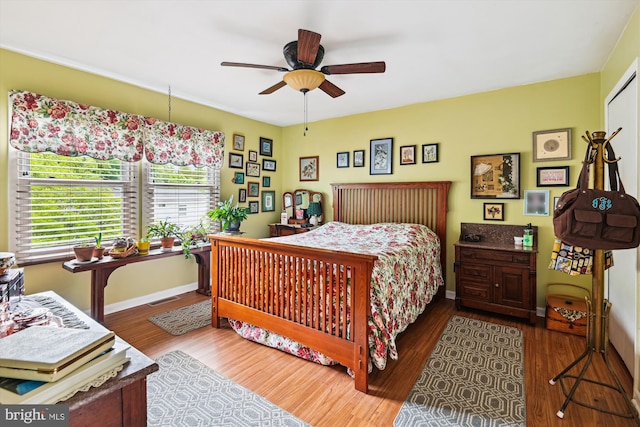 bedroom featuring wood finished floors, baseboards, and ceiling fan