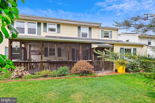 view of front of home featuring a sunroom and a front lawn