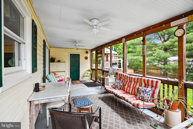 sunroom / solarium with a ceiling fan, an outdoor living space, and plenty of natural light