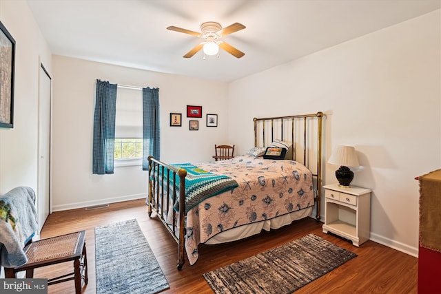 bedroom with wood finished floors, baseboards, and a ceiling fan