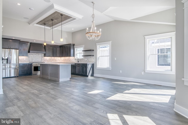 1306 N Barnegat Ave, Surf City, NJ 08008 - kitchen featuring appliances with stainless steel finishes, premium range hood, light countertops, high vaulted ceiling, and decorative backsplash