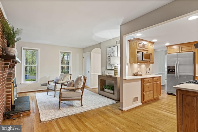 14906 Cranoke St, Centreville, VA 20120 - living area with a fireplace, arched walkways, light wood-style flooring, recessed lighting, and baseboards