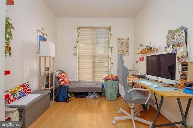 bedroom featuring wood finished floors and an office area