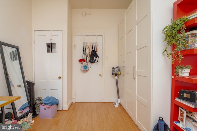 hallway with light wood-type flooring and baseboards