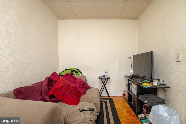 bedroom featuring a paneled ceiling, wood finished floors, and baseboards