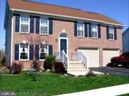 view of front of house featuring a front yard, a garage, and asphalt driveway