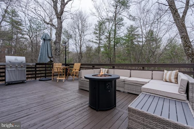 wooden deck with an outdoor living space with a fire pit and area for grilling