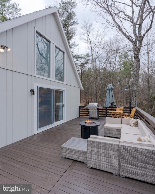 wooden deck with an outdoor living space with a fire pit and a grill