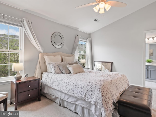carpeted bedroom with lofted ceiling, ceiling fan, baseboards, and ensuite bath
