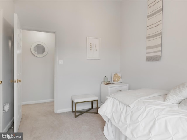 bedroom with light colored carpet and baseboards