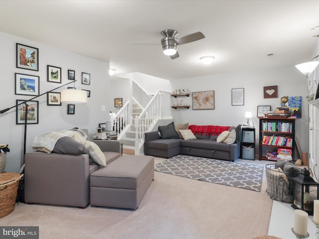 living room featuring carpet, stairs, and ceiling fan