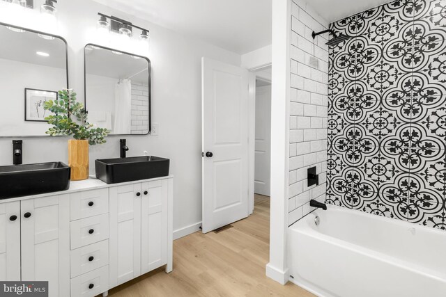 2506 Chelsea Ter, Baltimore, MD 21216 - bathroom with wood finished floors, shower / bathtub combination, double vanity, and baseboards