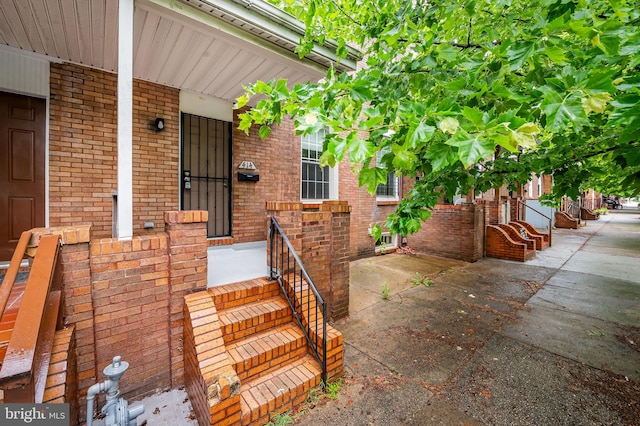 view of exterior entry featuring brick siding