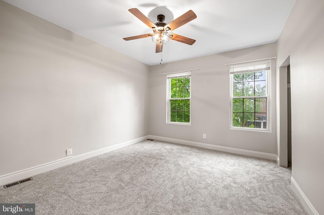unfurnished room featuring carpet, baseboards, and a ceiling fan