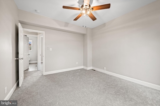 unfurnished room featuring carpet, ceiling fan, baseboards, and a smoke detector