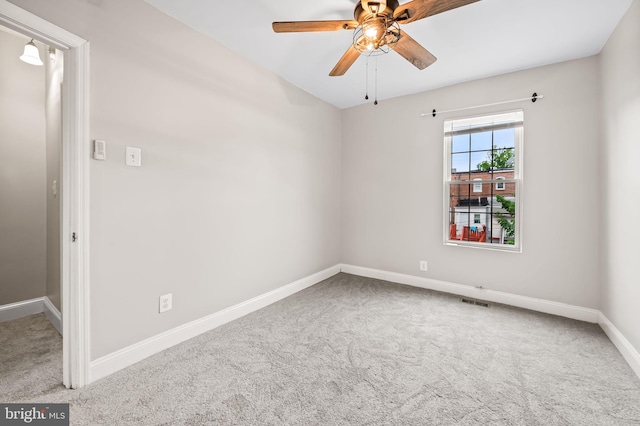 carpeted empty room with ceiling fan and baseboards