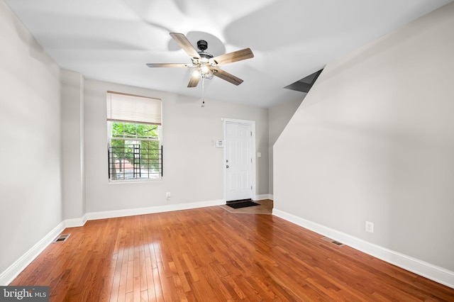 unfurnished living room with hardwood / wood-style flooring, ceiling fan, and baseboards