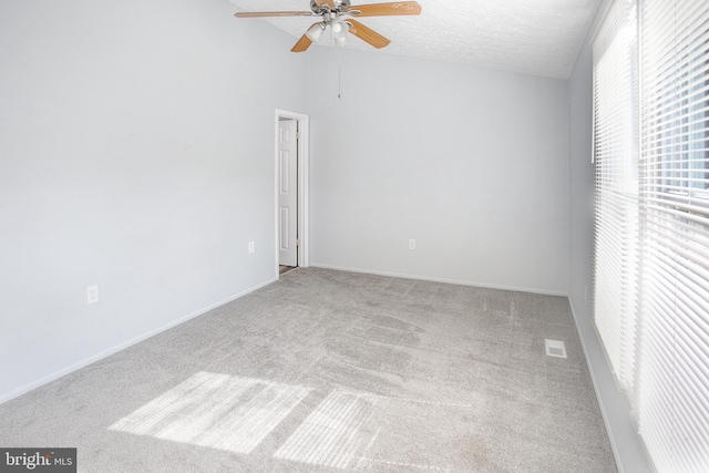 carpeted spare room featuring a ceiling fan and lofted ceiling
