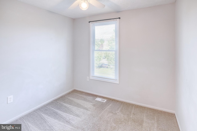 carpeted spare room featuring healthy amount of natural light, baseboards, and a ceiling fan